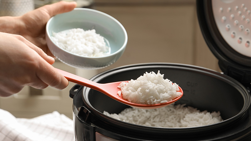 Cuociriso con riso, mestolo e scodella